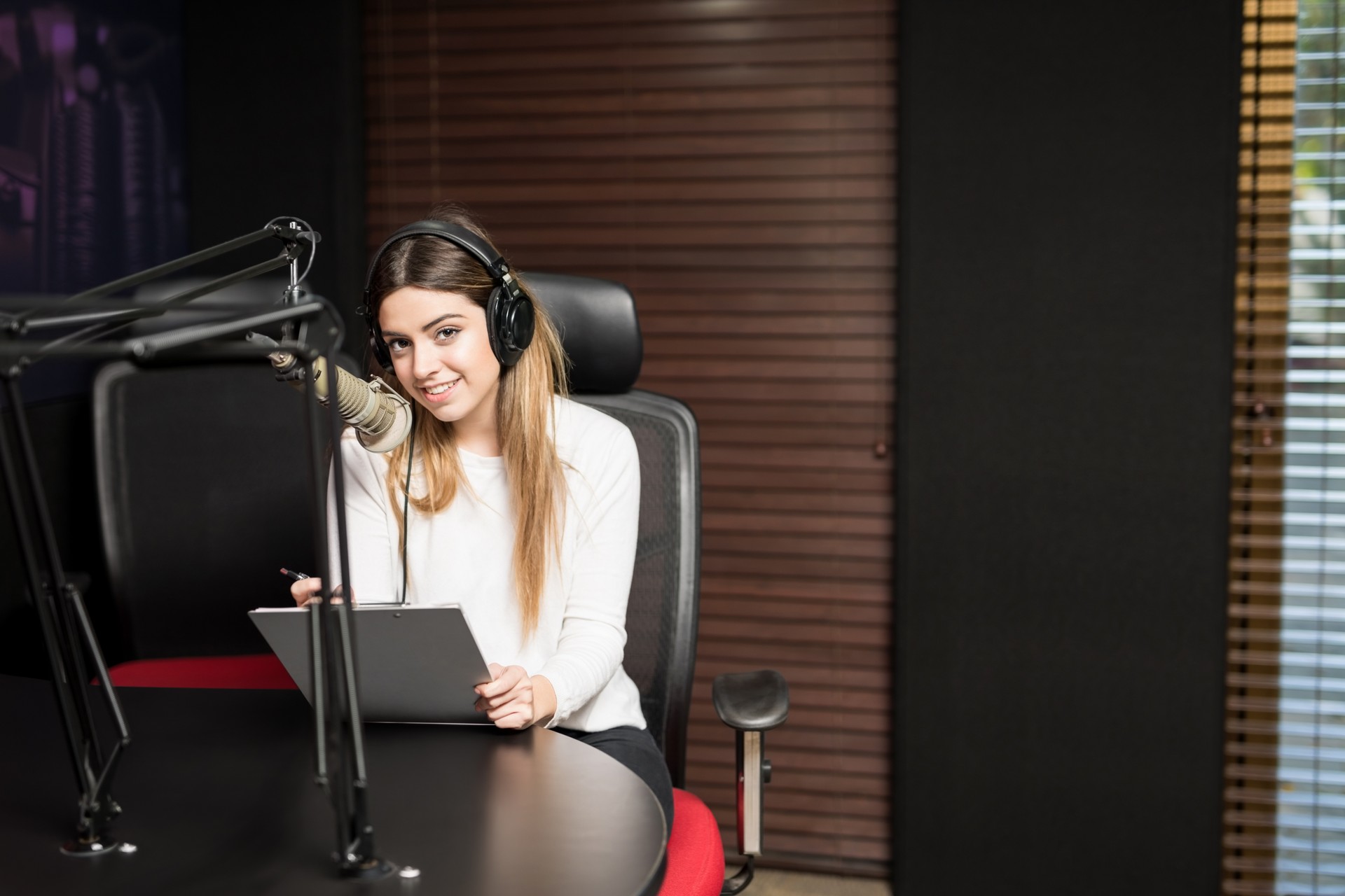 Latin woman hosting a talk show at radio station